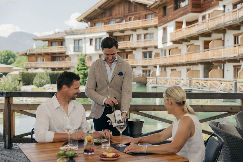 kaiserlodge-scheffau-am-wilden-kaiser-terrasse-mit-paar-am-tisch-1.webp