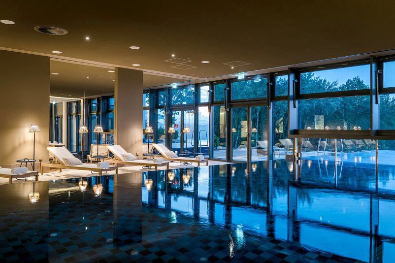 Infinity pool indoors and out at blue hour