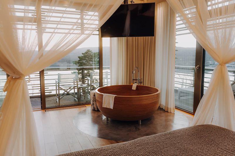 Suite with round wooden bathtub and lake view